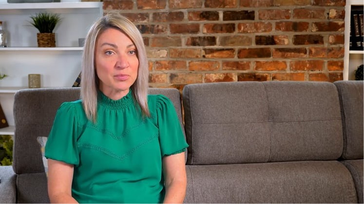 Woman on couch speaking about her Rhythm InTune experience